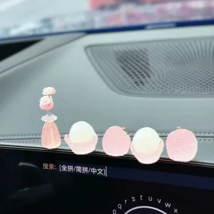 Car dashboard crystal lychee and rose ornament closeup showing glowing resin design.