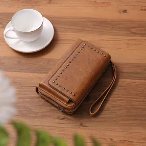 Vintage oil wax leather mini crossbody phone bag with metal studs and practical wrist strap.