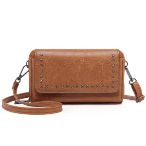 Detail view of a vintage brown oil-wax leather women's crossbody phone bag with metal studs.