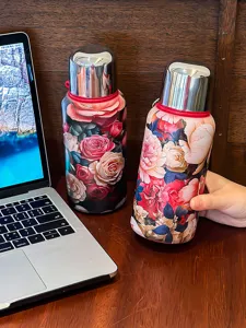 Bouteille thermos en acier inoxydable vintage avec motif floral élégant pour usage portable.
