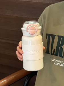 Stainless steel thermos bottle detail, portable straw cup with stylish leather sleeve.