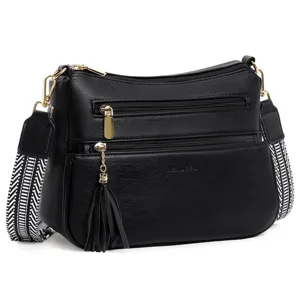 Close-up of black PU leather shoulder bag detail with multi-zipper pockets and gold hardware.
