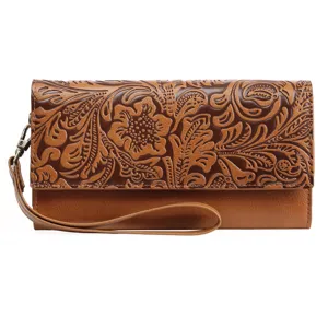 Detailed view of women's vintage embossed long wallet with floral tooling and wrist strap.