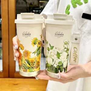 Detail view of portable stainless steel thermos cup with floral print and carry strap.