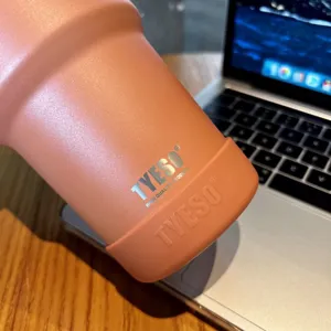 Gedetailleerde close-up van roestvrijstalen beker met siliconen beschermhoes op tafel.