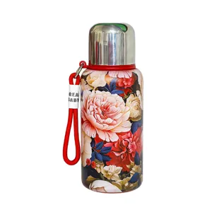 Bouteille isotherme en acier inoxydable vintage avec impression florale et sangle.