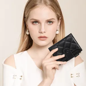 Detail view of a black quilted short wallet with elegant camellia floral snap closure.