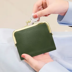 Dark green coin purse detail shot showcasing vintage kiss-lock clasp and key storage design.