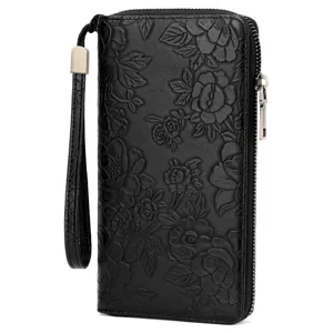 Black leather long wallet with embossed floral design, wrist strap and zipper closure details.