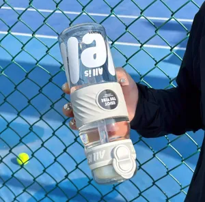 Large capacity clear plastic sports water bottle with straw and silicone sleeve for outdoor use.