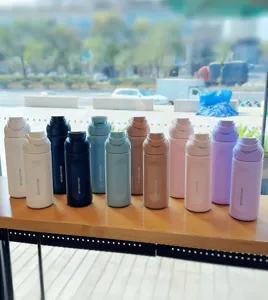 Detailed view of colorful stainless steel sports water bottles array, portable travel insulated cup.