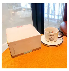 Detailed view of creative cartoon ceramic mug with 3D cat inside, saucer and box.