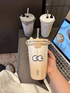 Vue de détail d'un gobelet en acier inoxydable avec yeux de dessin animé et finition dégradée.