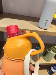 Vue détail de bouteille d'eau de sport portable, gourde isotherme en acier inoxydable avec poignée.