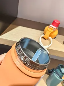 Vue de detail de la bouteille isotherme en acier inoxydable, grand format portable avec paille.