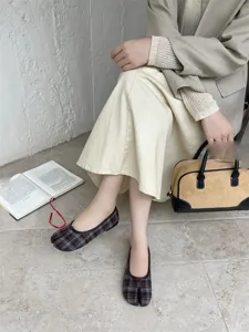 Vista dettagliata di scarpe basse a punta fesa con motivo scozzese, comode e chic.