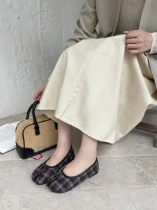 Vista dettagliata di comode ed eleganti scarpe basse con punta spaccata a quadri.