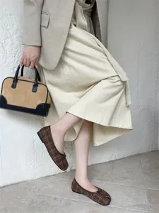 Vista di dettaglio di scarpe basse scozzesi a punta divisa da donna dal design retrò.