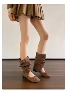 Detailansicht brauner Wildleder-Split-Toe-Ballerinastiefel mit Schnallen und Schleife.