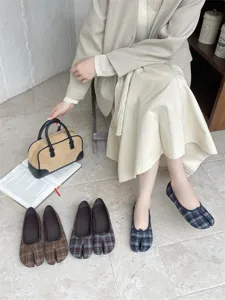 Vista dettagliata di scarpe basse con punta divisa, motivo a quadri e stile comodo e chic.