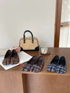 Vista di dettaglio di scarpe basse con punta divisa in classico motivo a quadri morbido.