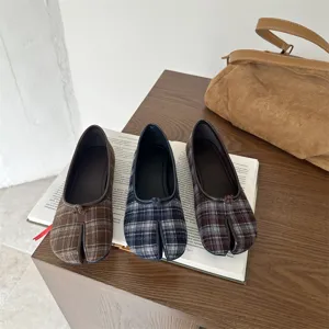 Vista dettagliata di scarpe basse alla moda con punta divisa a quadri e bottoni graziosi.