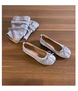 Detailansicht von Jeans-Split-Toe-Ballerinas mit abnehmbaren Stiefelstulpen und Schleifchen.