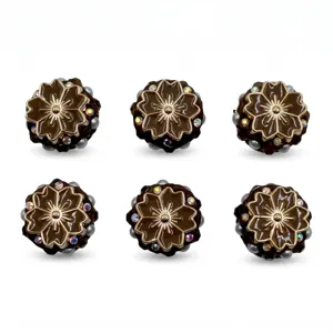 Detailweergave van bruine bloemharskraaltjes met gouden rand, parels en strass voor knutselwerk.