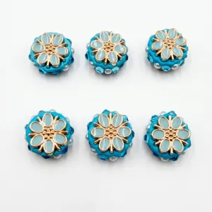 Gros plan de perles de fleurs en résine bleue de 22mm avec incrustation dorée pour bijoux.