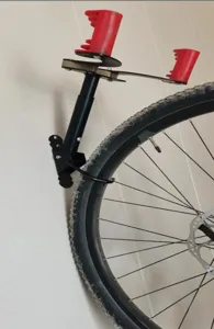 Dettaglio del supporto da parete per bici con braccio telescopico e gancio ruota.