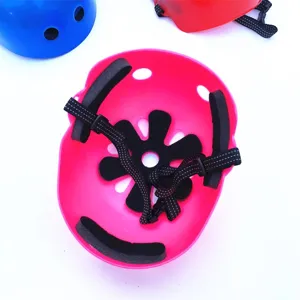 Kids sports safety helmet detail, pink protective gear with black padding and adjustable strap.