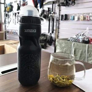 Botella de agua de plástico negro para ciclismo de montaña con cubierta antipolvo y diseño.