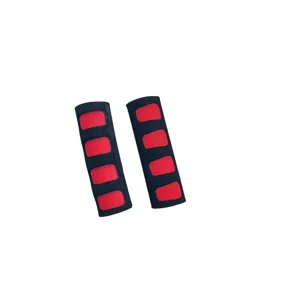 Close-up detail of soft foam bicycle handlebar grips in black and red color design.