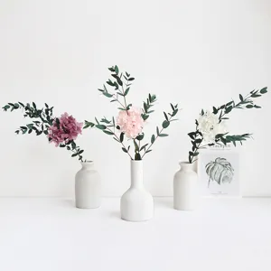Preserved hydrangea bouquet with eucalyptus leaves and ceramic vases for home decor.