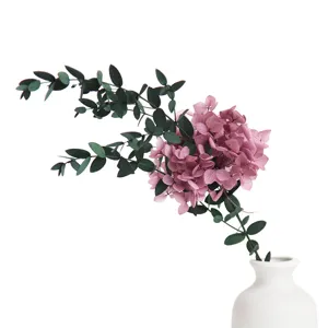 Preserved hydrangea bouquet with eucalyptus leaves in white vase, ideal for home decor.