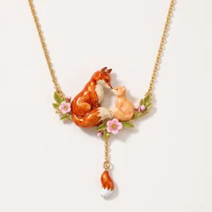 Enamel fox necklace detail, cute mother and baby fox pendant with flowers on gold chain.