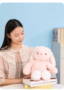 Close-up detail of a soft pink plush bunny rabbit toy, featuring floppy ears and cozy feel.