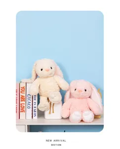Soft plush rabbit stuffed animals displayed on shelf with books, cute pastel rabbit toys.