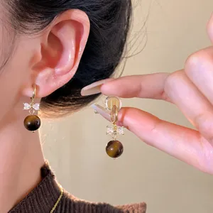 Jolies boucles d'oreilles œil de tigre et nœud zircon automne pour femmes élégantes.