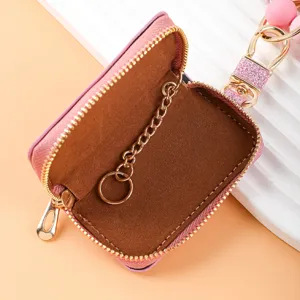 Compacto mini estuche para llaves de cuero rosa con cadena interior y pulsera de cuentas.
