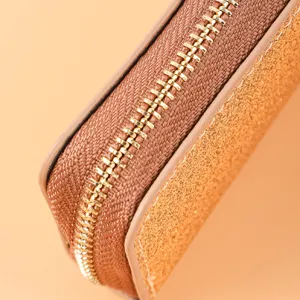 Primer plano detallado de la elegante cremallera metálica y la textura de cuero brillante.
