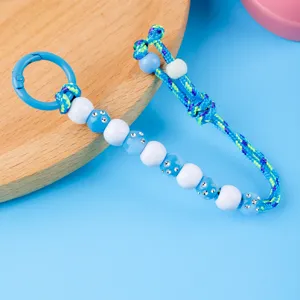 Detailed view of handmade beaded braided keychain lanyard with blue rhinestones and metal ring.