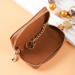 Mini llavero de cuero marrón con correa de cuentas, monedero compacto elegante.