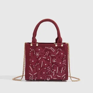 Bolso de mano de satén burdeos con exquisito bordado floral y delicadas perlas blancas.