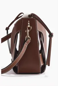Vista dettagliata di un'elegante borsa in pelle marrone e tela con design a ritaglio.