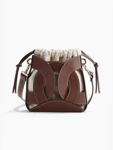 Elegante borsa a secchiello bicolore con sacchetto in tela e rivestimento in pelle.