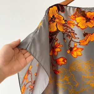 Vue detaillee du tissu de robe d'ete fleuri leger, texture de soie douce, style de vacances.