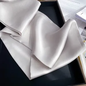 Gros plan de foulard en soie unie, texture lisse, style foulard élégant ou accessoire de cheveux.