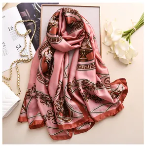 Elegante foulard in seta rosa con raffinato motivo barocco e catene per donne alla moda.
