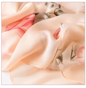 Detailopname van een zachte roze kunstzijden sjaal met elegante olieverf bloemenprint.